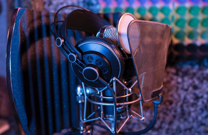 professional studio headphones resting on a condenser microphone with a pop filter, headphone microphone madrid 4k