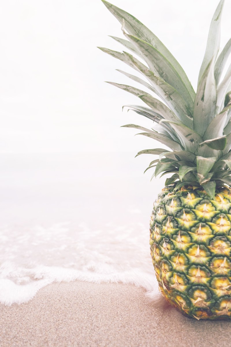 single fresh pineapple sitting on the ocean shoreline, pineapple on the beach 4k