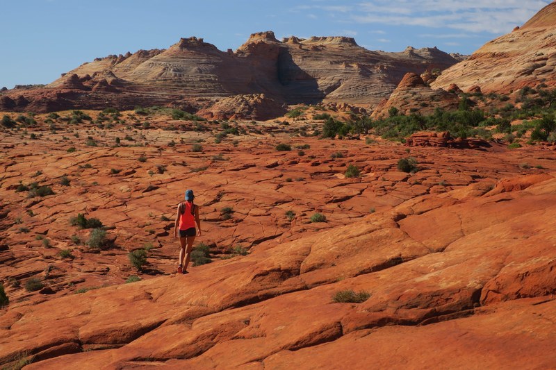 hiker walks alone through rocky terrain of the wave trail desert, solo desert hikes 4k