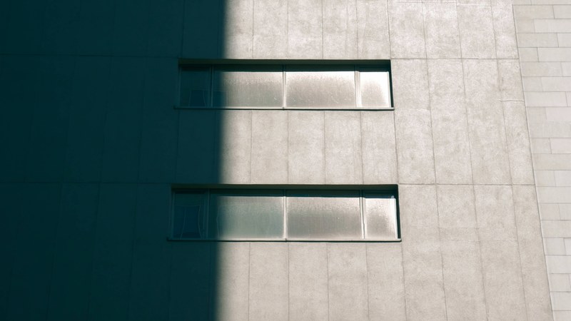 concrete building with horizontal windows half in shadow, go back to the shadow 4k