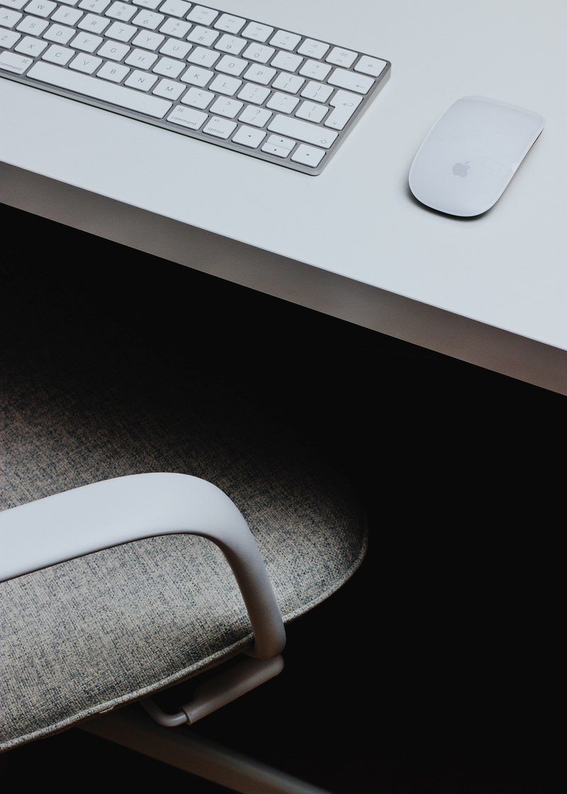 the edge of a white desk with an apple keyboard and mouse, home office 4k
