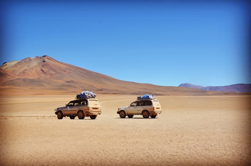 two off road vehicles in a mountain desert under clear sky, off road trip through the scorching desert 4k