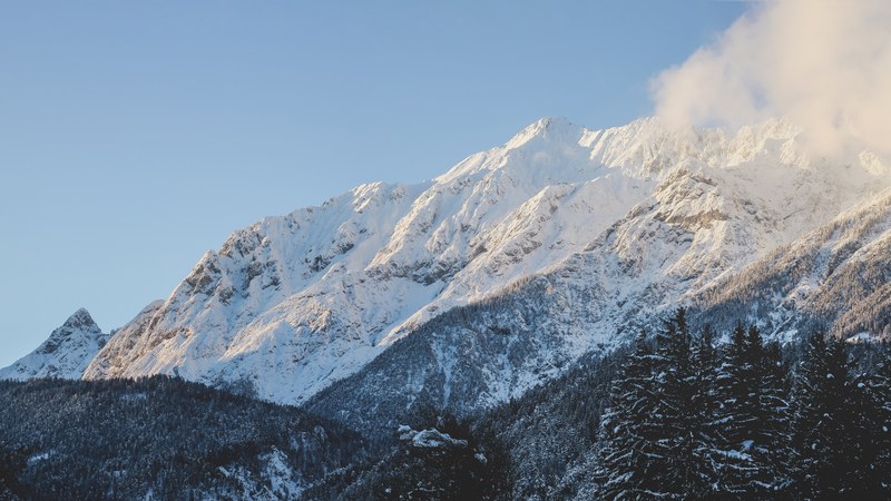 white mountain ridge soaring above wooded slopes in vomp, winter wonderland 4k