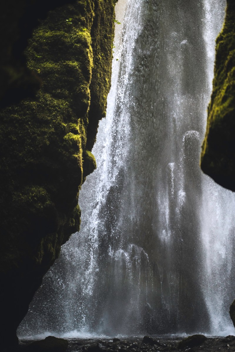 a waterfall flowing downhill on mossy rock walls in iceland, iceland rock waterfall 4k