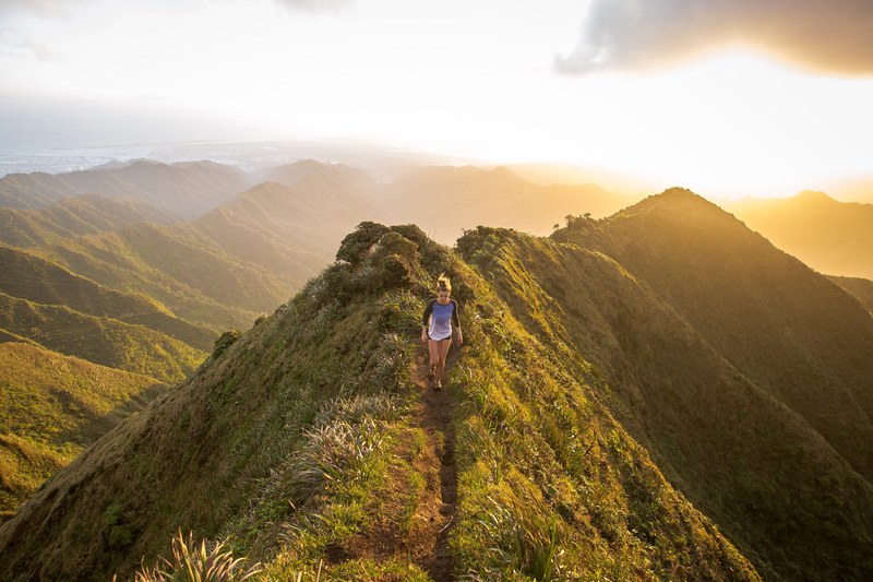 a woman hiking along the top of a grassy mountain with the sunset in the background, mountain hiking sunset follow kalenemsley on ig 4k