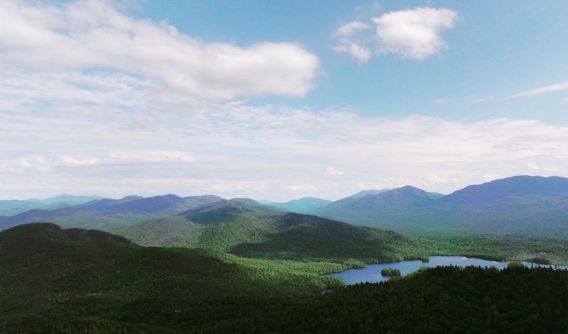 a green hilly landscape with a small lake, remote lake in the highlands 4k