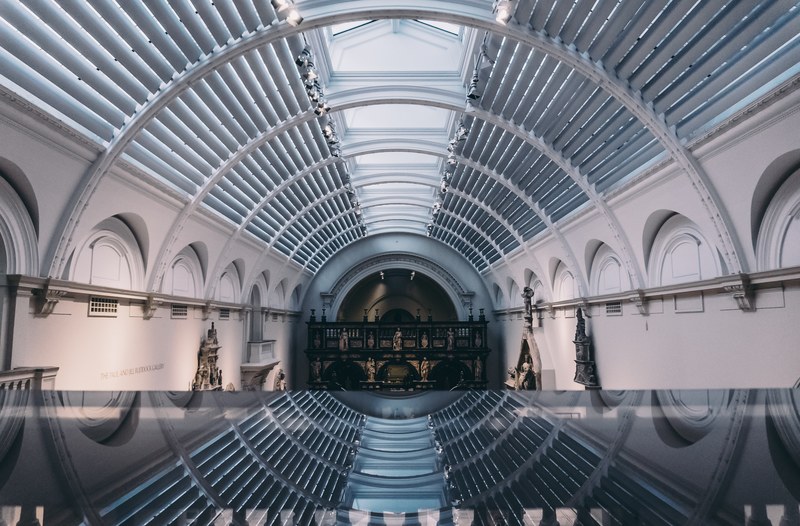 a tunnel like corridor in a museum with sculptures and ornaments on the walls, museum tunnel 4k
