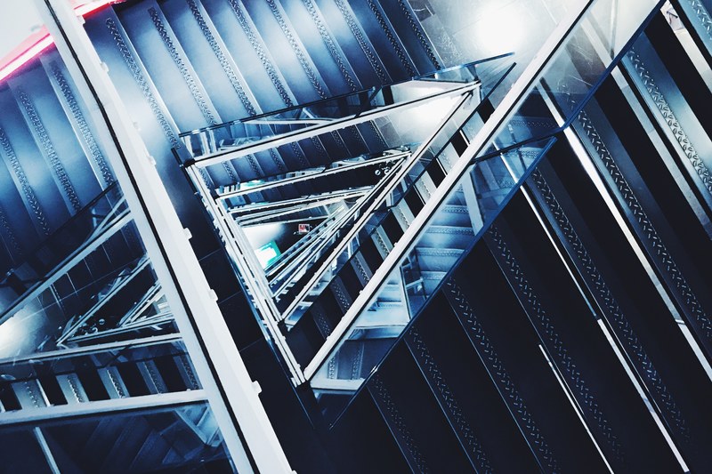 view down a winding steel staircase in milan, winding industrial stairs 4k