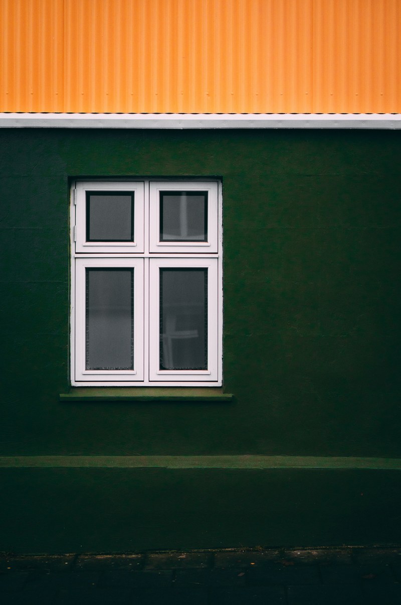 window with white frame on green wall with orange roof in reykjavk, window of iceland 4k