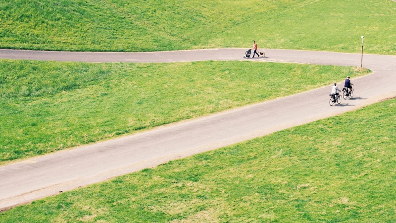 people walk and ride bikes on a rural road through the countryside, staying active 4k