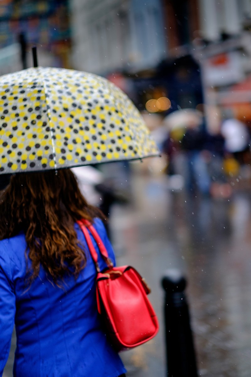 a woman holds a polka dotted umbrella in rainy london chinatown, another rainy day 4k