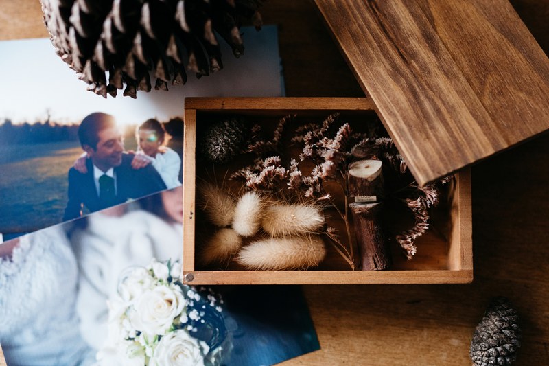 fauna in a wooden wedding box with photos on a wooden desk, wedding box 4k