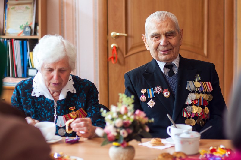 a retired and old ukraine soldier sitting with his wife and medals on his jacket, _retired ukraine soldier 4k
