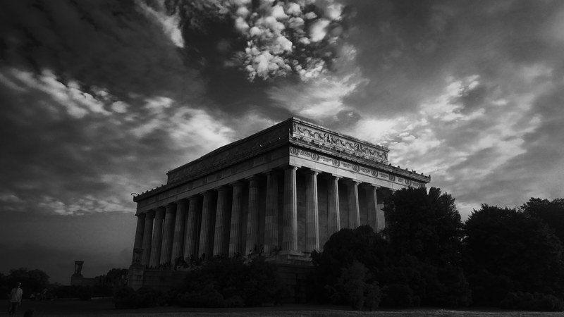 black and white long shot of classic ancient building with pillars cloudy sky and trees, ancient pillars building 4k