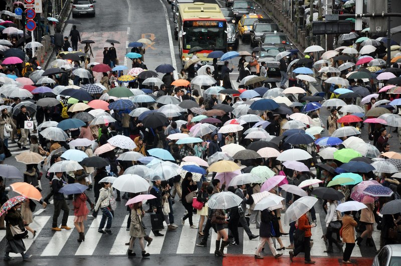 a crowded crosswalk in tokyo on a rainy day, busy street in shibuya tokyo during rain 4k