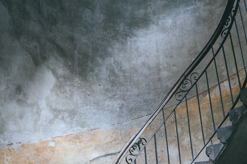 a rusty railing in the stairway of an old residential building in budapest, gloomy stairway 4k