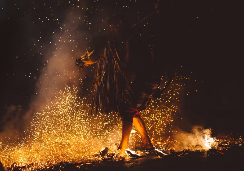 a man walking on fire with his feets burning and sparks every where in ubud, sanghyang djaran 4k
