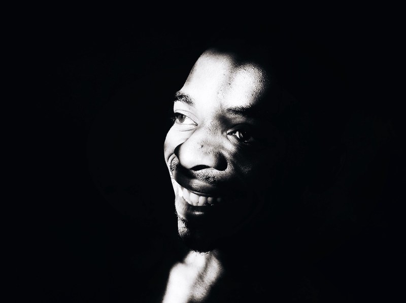 black and white close up shot of mans face in shadow mlandizi primary school, friends 4k