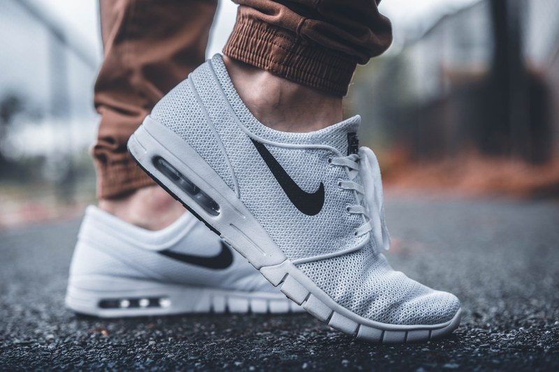 a close up shot of a pair of white nike shoes on a male, man in nike shoes 4k