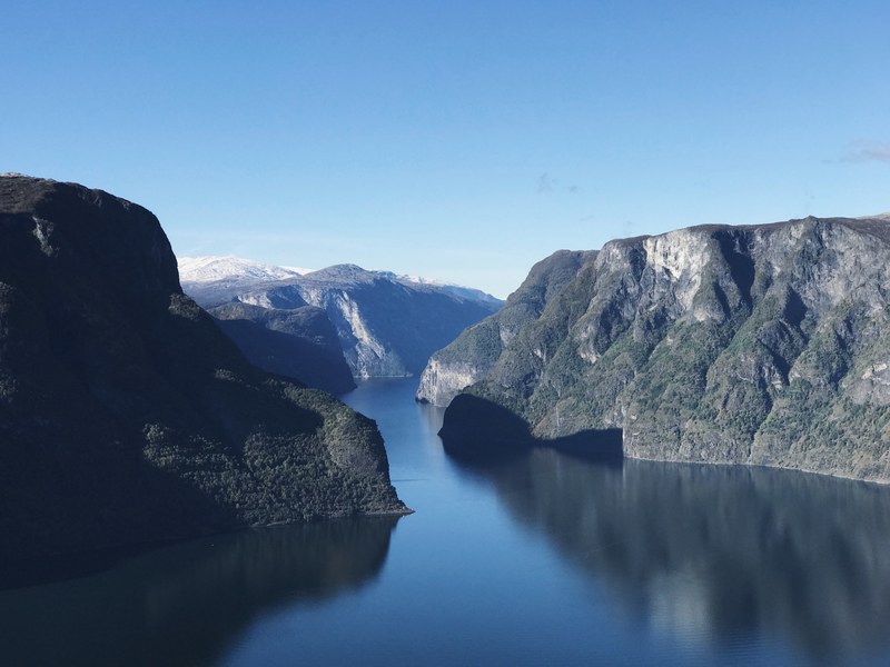 still water between tall fiords under a blue sky in aurland, norwegian fiords on a sunny day 4k