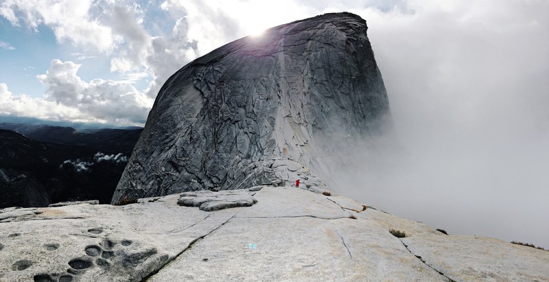 view from a flat ridge on a scaly summit shrouded in clouds, blue skies at yosemite 4k