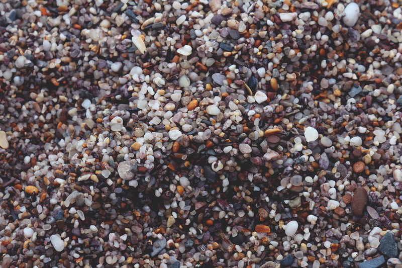 a top view of a large number of pebbles of various color shape and size, colorful shingle 4k