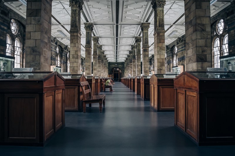 a lone man sitting on a bench in a museum in london, silence in the museum 4k