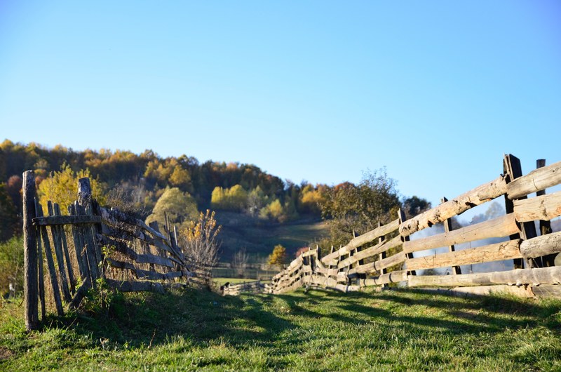 a wooden fence on a hill in the countryside, rustic fence 4k
