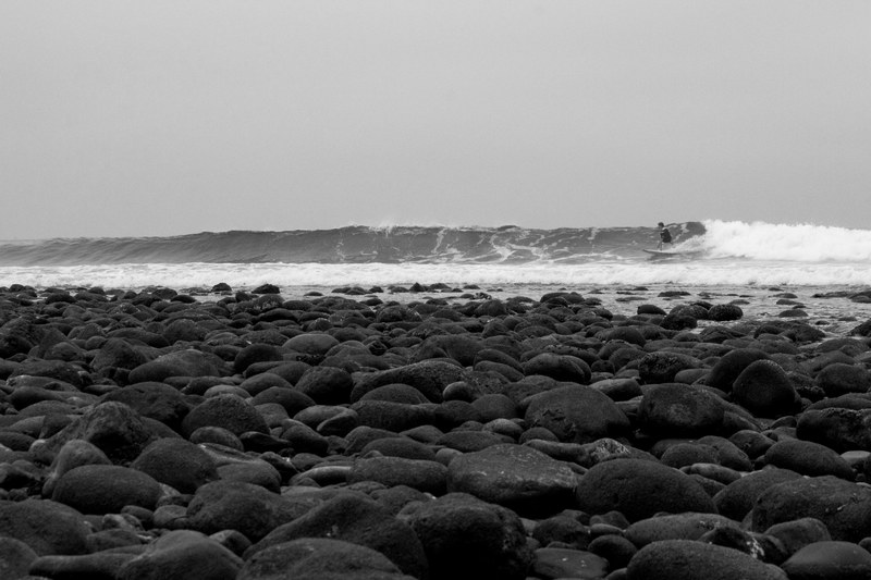 surfer surfing viewed from the rocky trestles beach, distant surfer watched from the rocks 4k