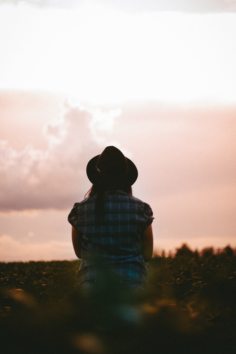 a woman staring out at the shapes of the cloud during a sunset, cloudy at dusk 4k