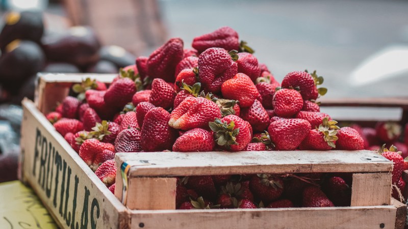 crate overflowing with fresh red strawberries at the market, farmers market fruit 4k