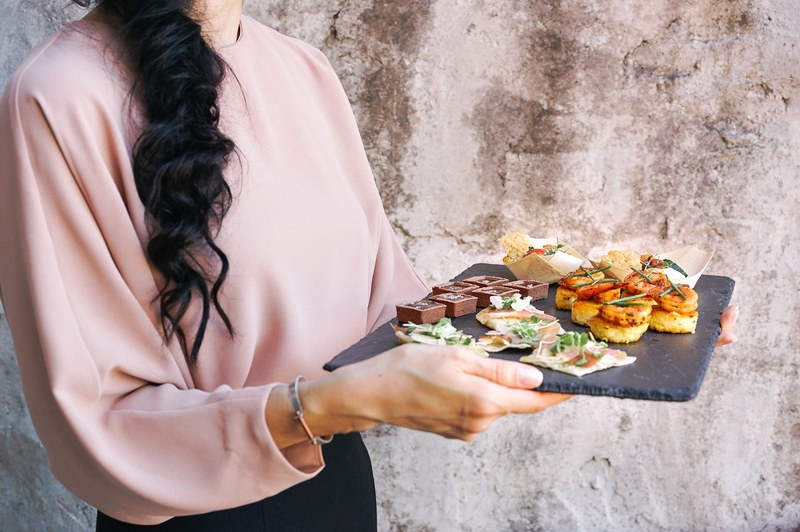 woman holds a tray of chocolate and pastry hors doeuvres, tray of hors doeuvres 4k