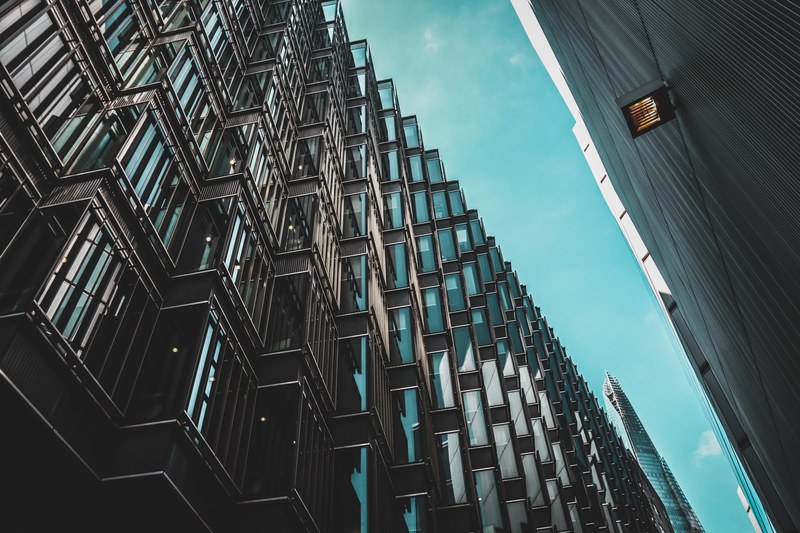 a long wavy glass facade of an office building in a city, undulating facade 4k