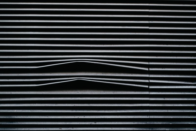a black and gray background pattern of striped metal lines taken in london, metal line pattern background 4k