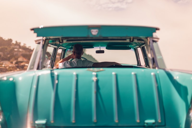 man sitting in stylish teal classic car looking out window during daytime, man sitting in teal car 4k