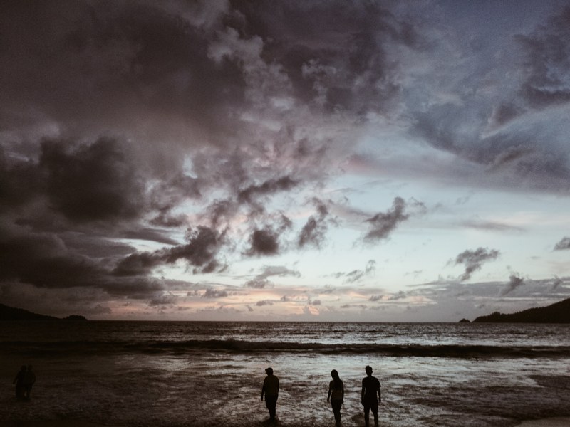 three silhouettes looking at the stormy skies by the ocean in patong phuket thailand, silhouettes looking at the sky 4k