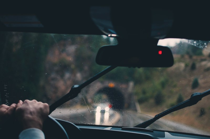 view from the car interior through the windscreen with wipers during heavy rain approaching a tunnel, view from the car interior during heavy rain 4k