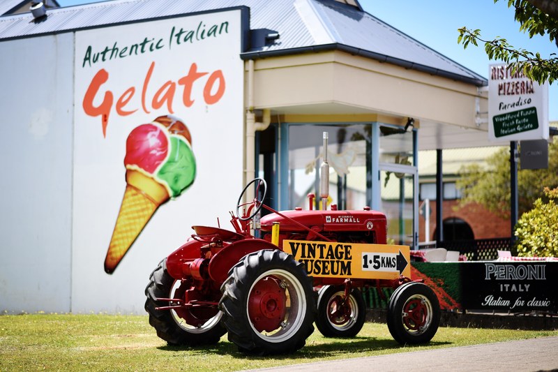 a vintage tractor sitting outside of a gelato shop in new zealand, new zealand vintage 4k