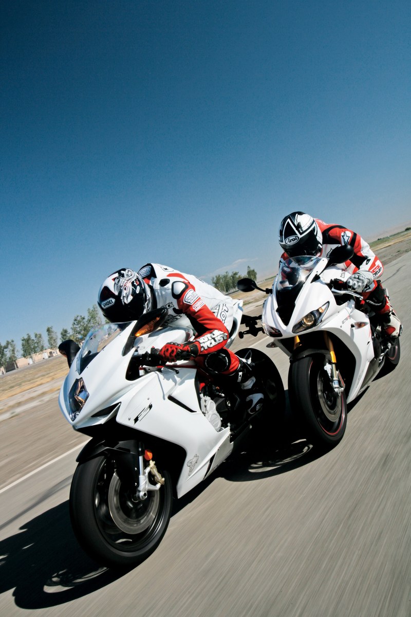 two people in crash helmets on white motorcycles racing on a track under a blue sky, white motorbikes racing 4k