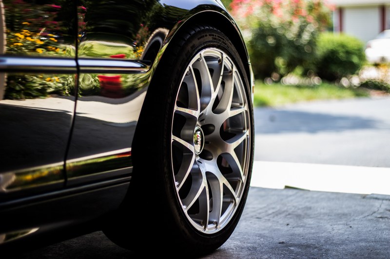 a side shot of a tire and part of the vehicle, macro of the aluminum rim wheel 4k