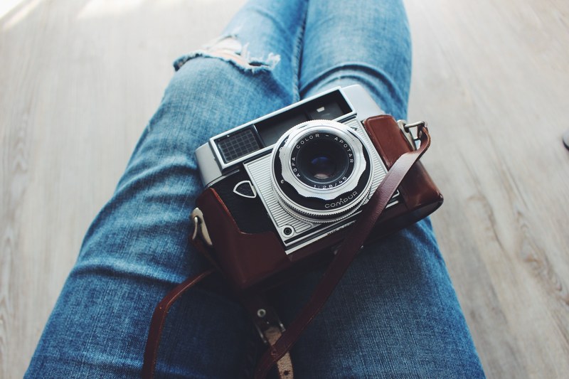 a vintage film camera on a womans lap, _silver vintage camera 4k
