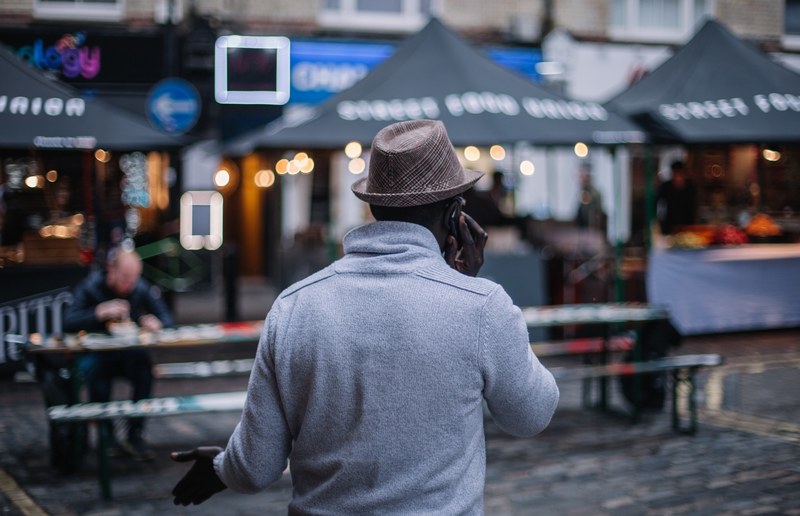 a man walking down the street near picnic tables in downtown soho, soho market 4k