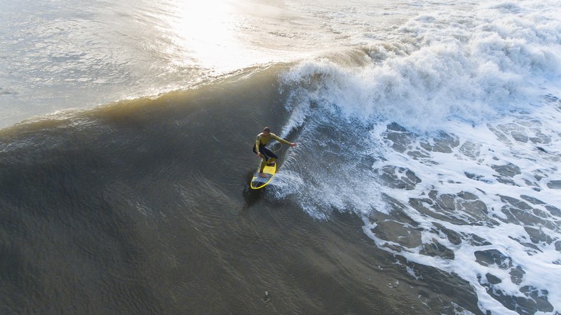 drone view of surfer riding the wave at beaches jacksonville beach florida united states, riding the crest of a wave 4k