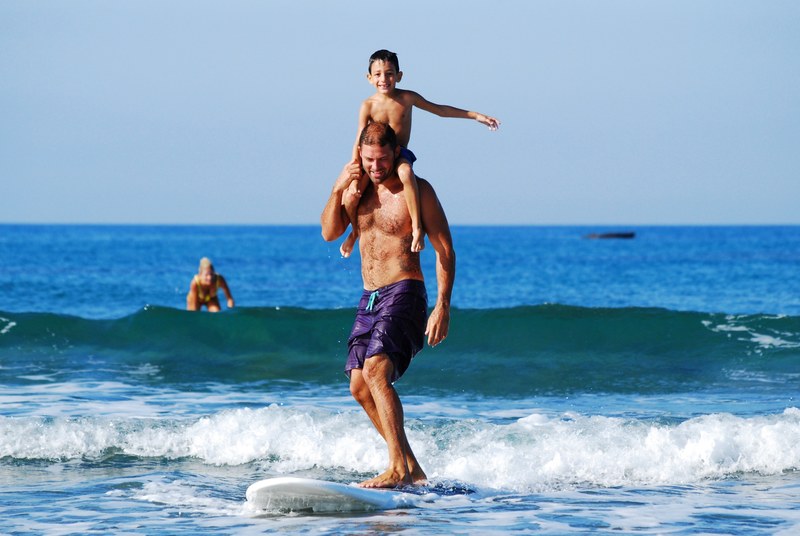 a man and his son surfing on a surfboard in the sea in cyprus, cyprus father and son 4k