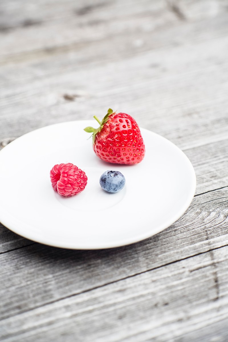 small portion fruit with strawberry raspberry and blueberry on a white plate, light dieting 4k