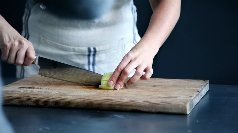 chef slices an onion on a cutting board, cutting onions 4k
