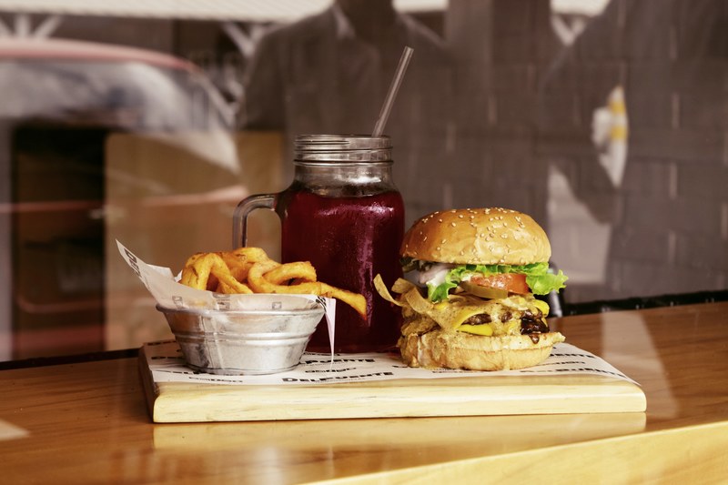cheeseburger red juice drink and a basket of fries at a restaurant, burger fries and juice 4k