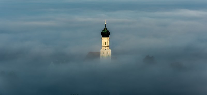 top of a historic building in bavaria breaks through the clouds, bavaria building in fog 4k