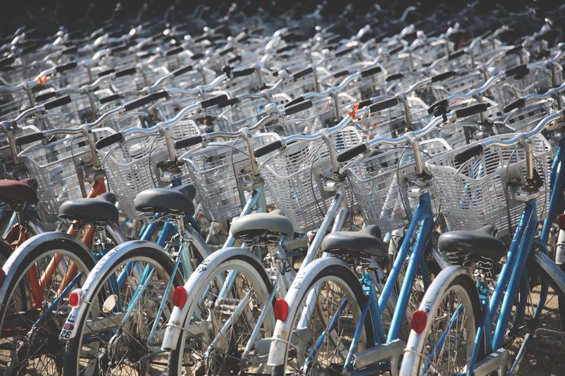 rows of vintage rental bicycles form a pattern of handle bars and baskets, endless rows of bikes 4k