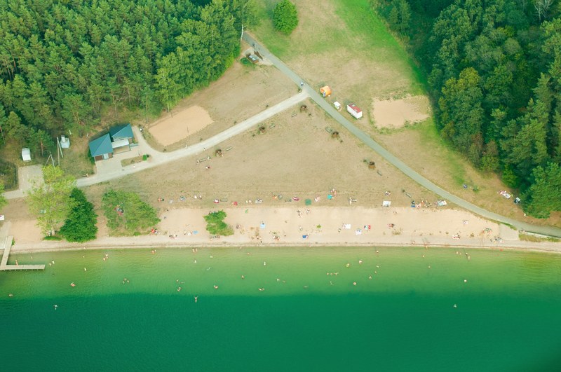 drone aerial view of the coastal road by the forest and a crowded beach, coastal roads drone view 4k
